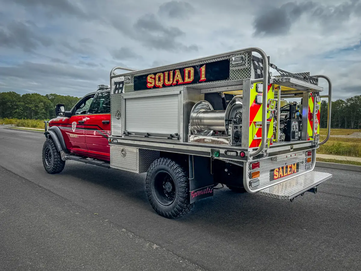 Rear-left three-quarter exterior view with chevron rear panel and open rear equipment bay.
